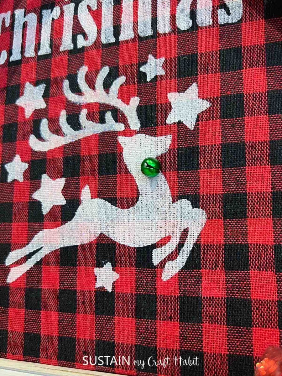 Close up of Stenciled reindeer on a buffalo check background. 