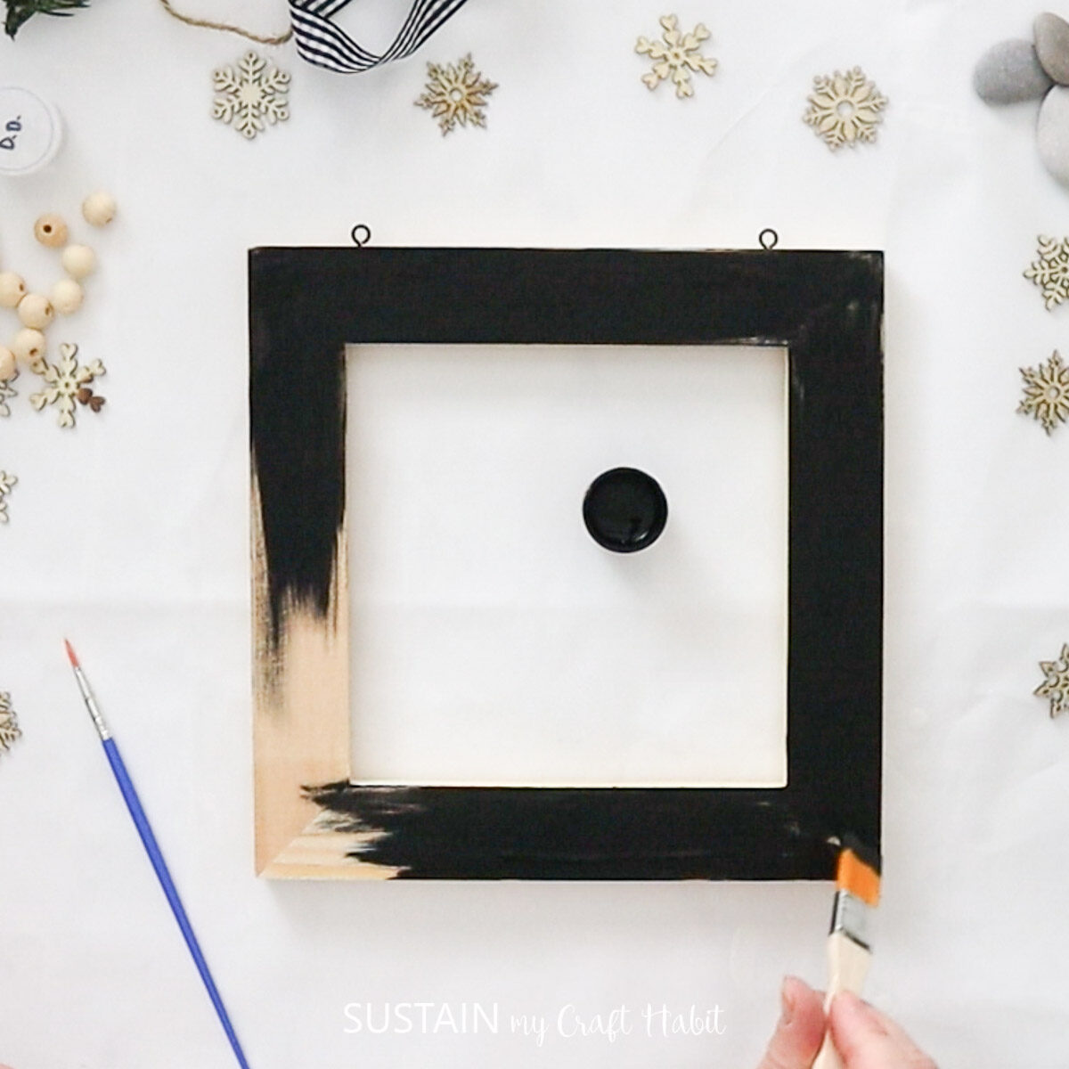 Painting a wood frame black.