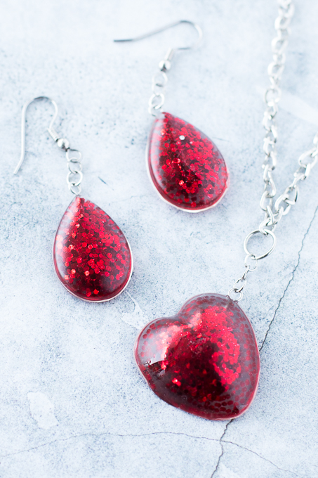 Red dangle earrings and a heart pendant made from resin.