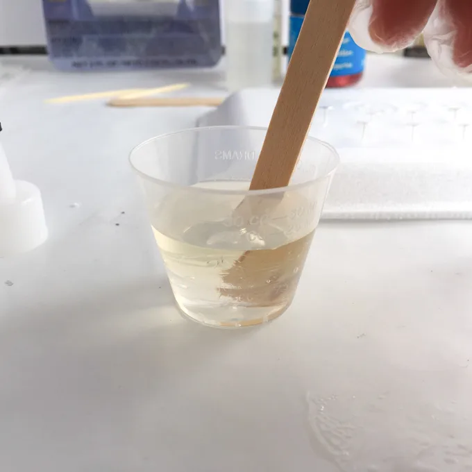 Stirring the resin with a wooden craft stick.