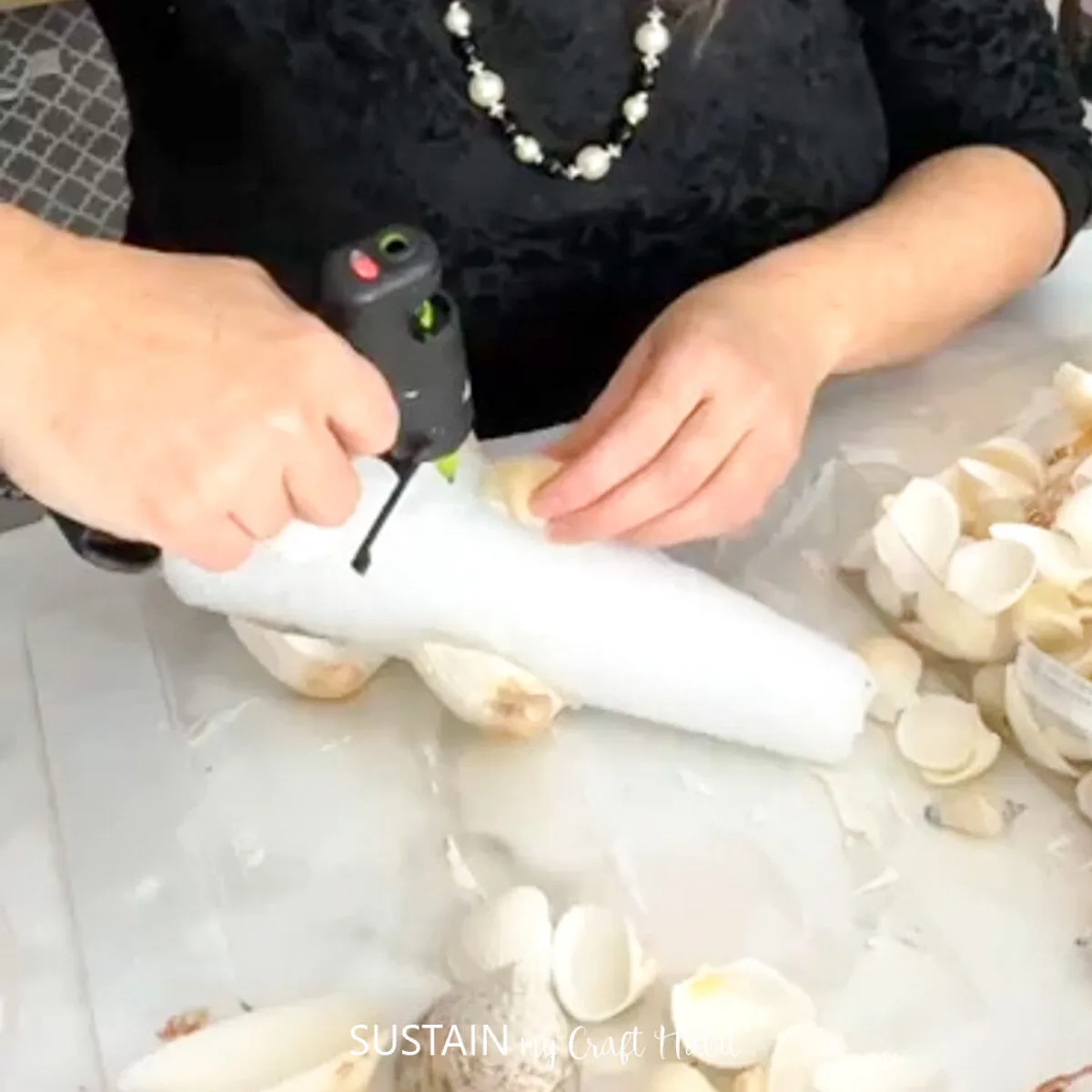 Adding hot glue to a foam cone.