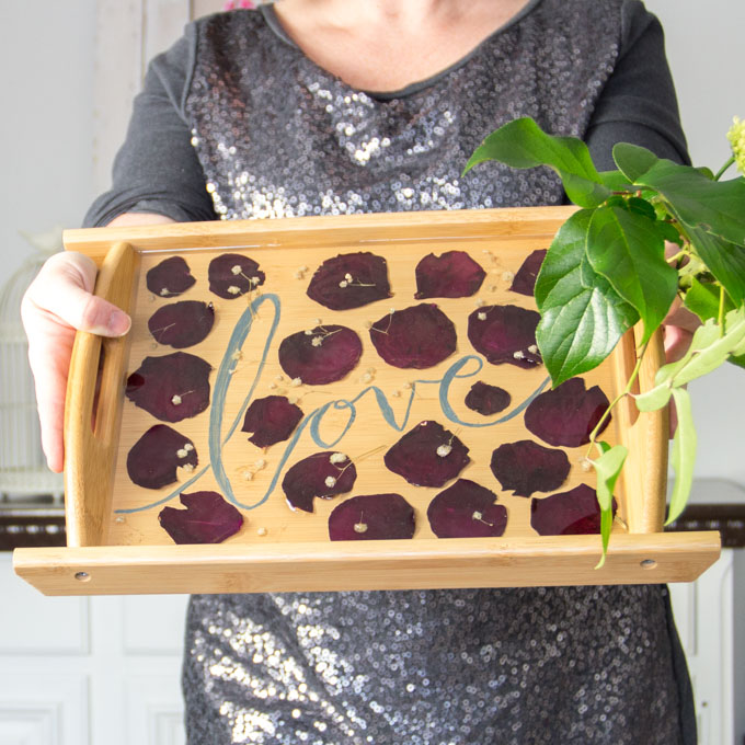 Woman holding a dried rose petal serving tray.