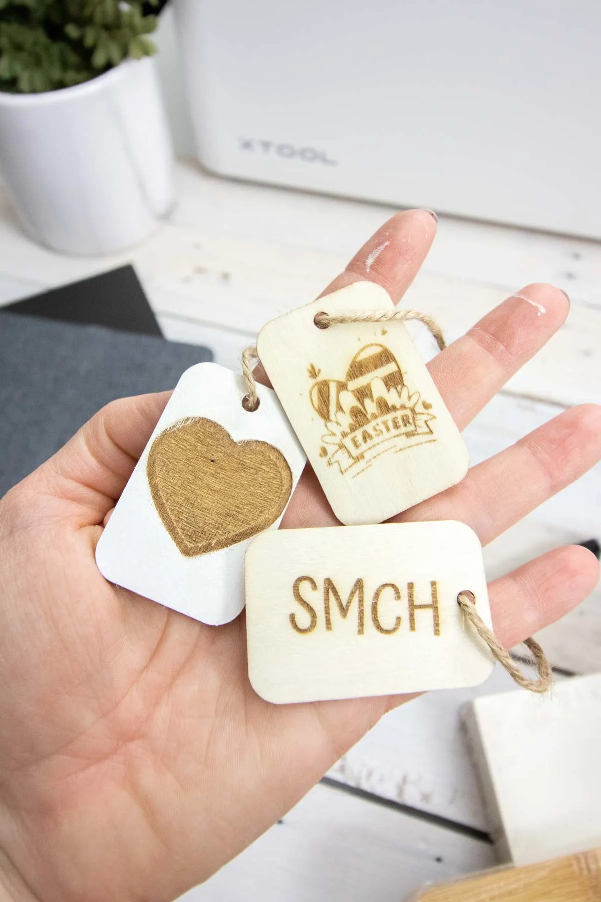 Close up images of three small wood tags engraved with the XTool M1 laser machine.