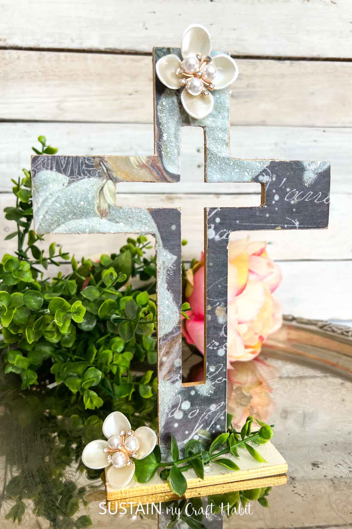 Wooden cross decorated with decoupage and embellishments.