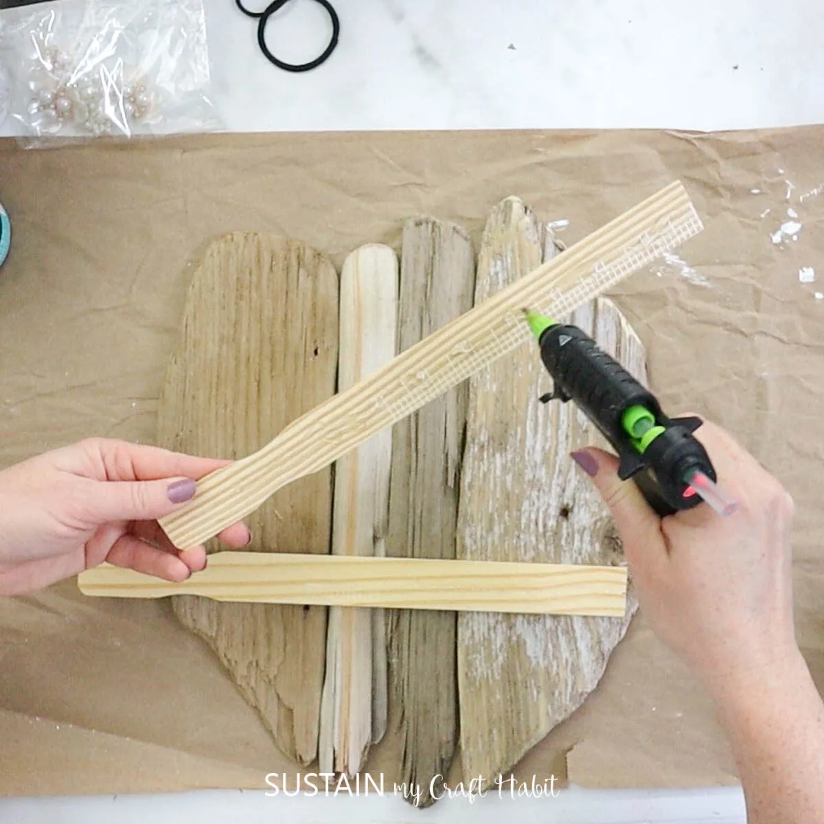 Adding hot glue to paint sticks.