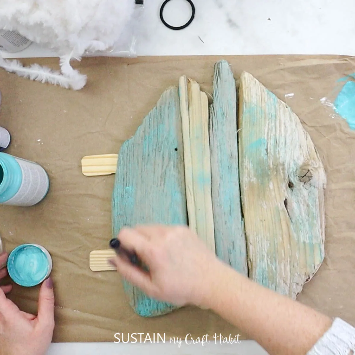 Painting driftwood with blue paint.