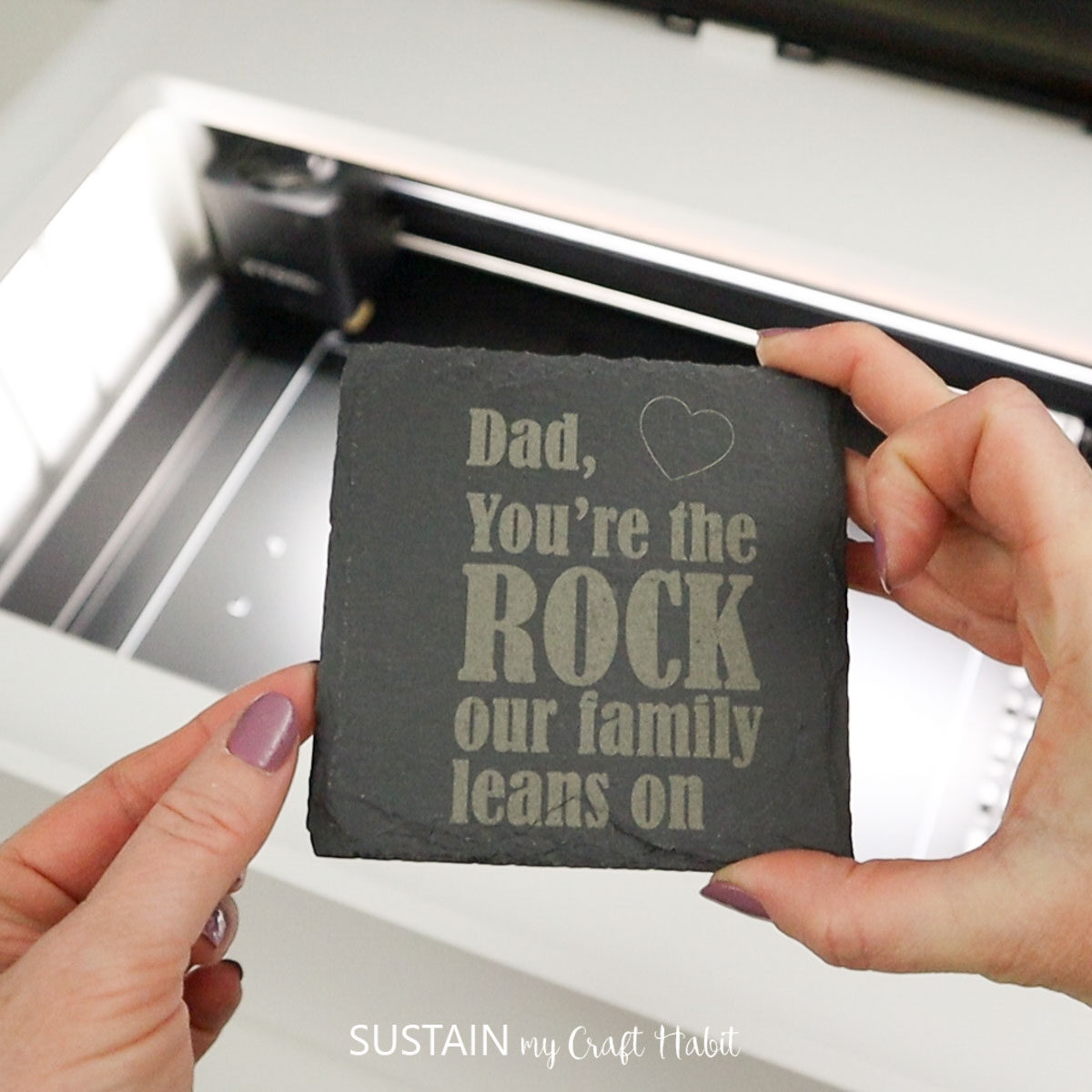 Hand holding an engraved slate coaster Father's Day gift idea.