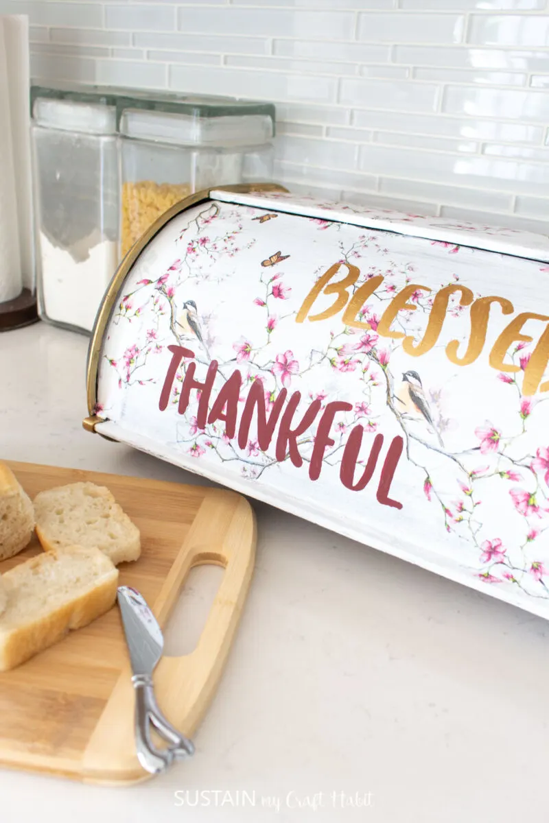 Upcycled bread box decorated with decoupage and the words "blessed" and "thankful."