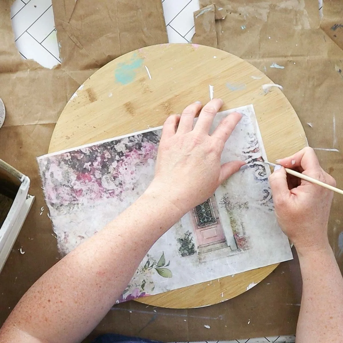 Using a wet paintbrush to remove excess paper.
