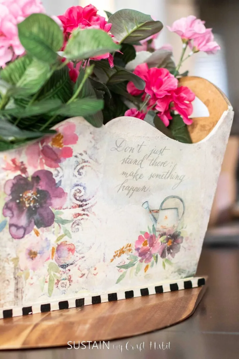 Close up of an outdated magazine holder decorated with decoupage and floral.