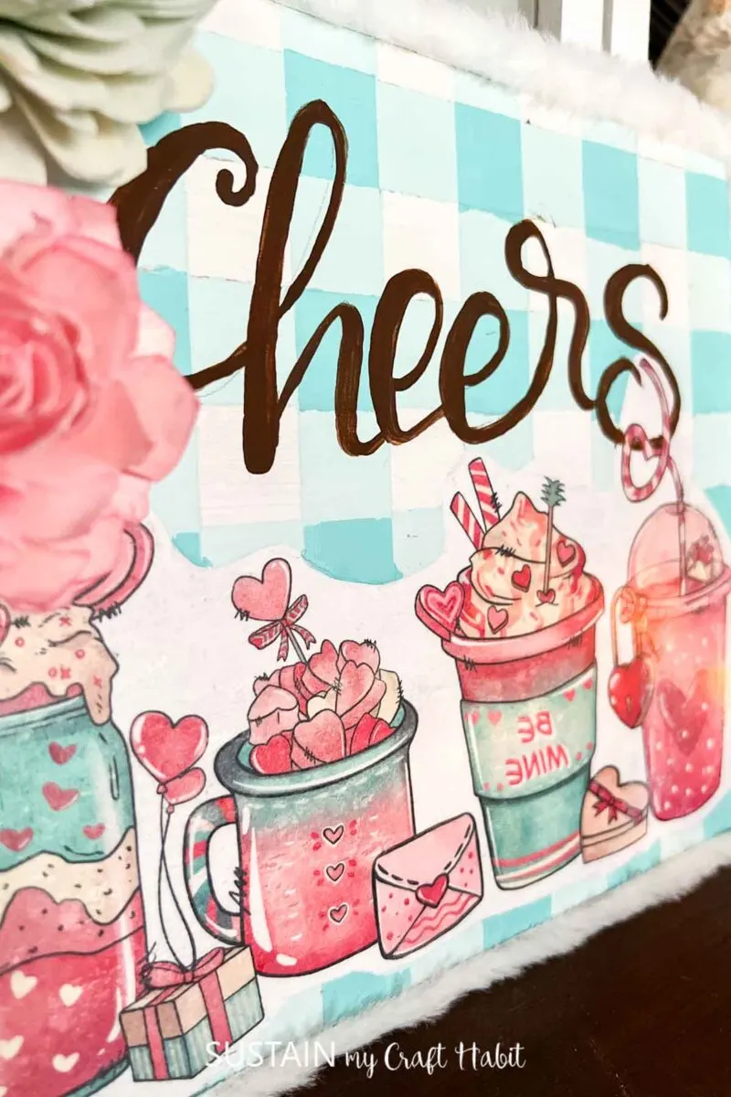 Hot cocoa bar sign decorated with a graphic image, ribbon and flowers.