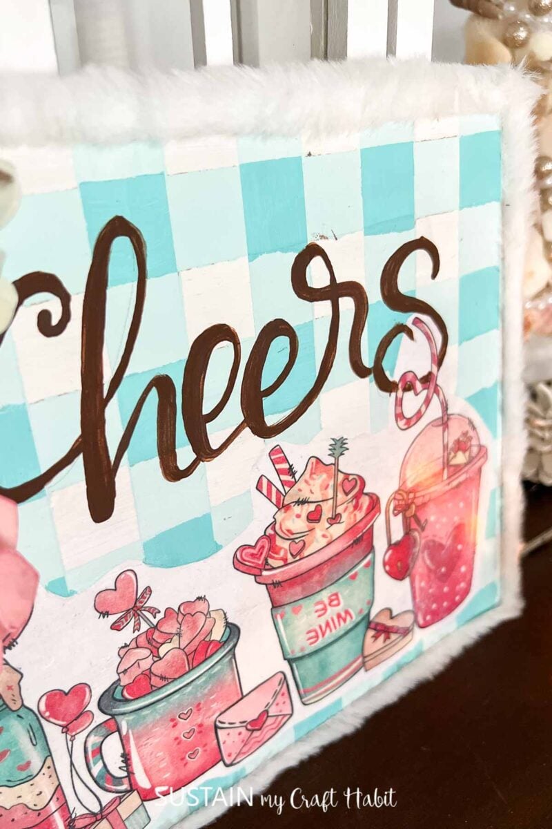 Hot cocoa bar sign decorated with a graphic image, ribbon and flowers.