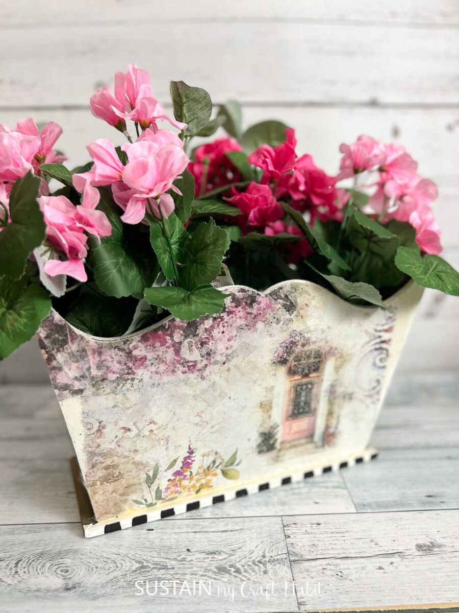 Outdated magazine holder decorated with decoupage and floral.