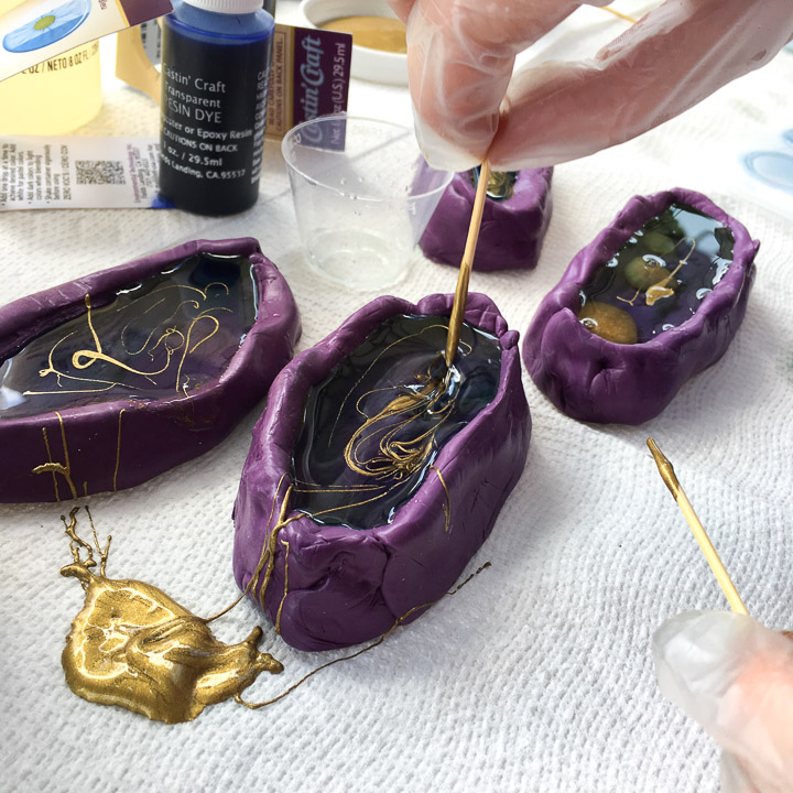 Adding gold paint to the resin.