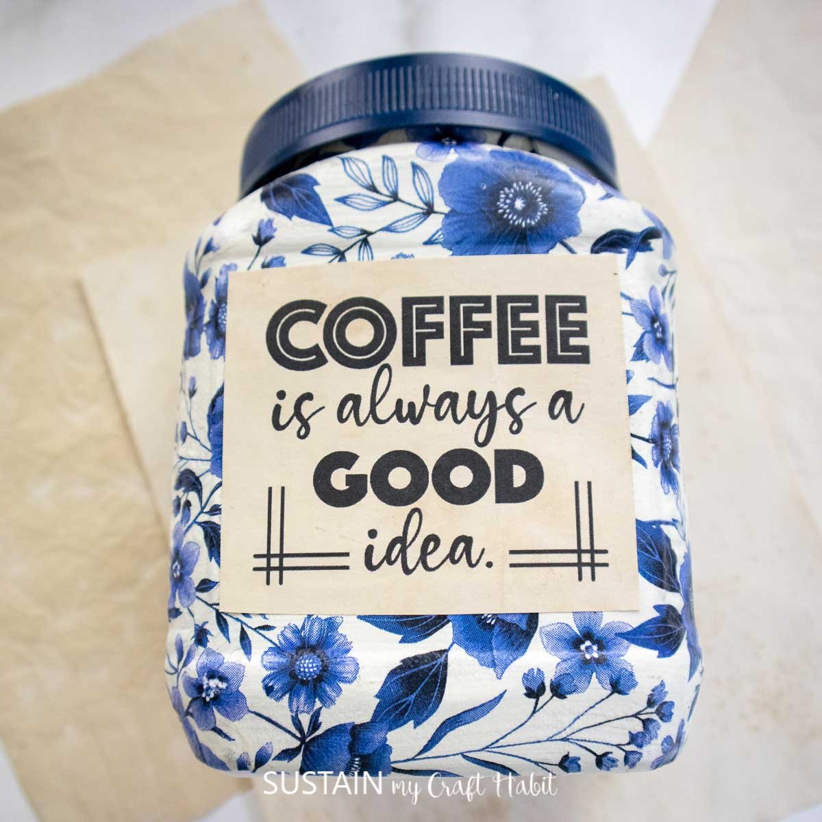 Upcycled coffee canister decorated with a printable saying.