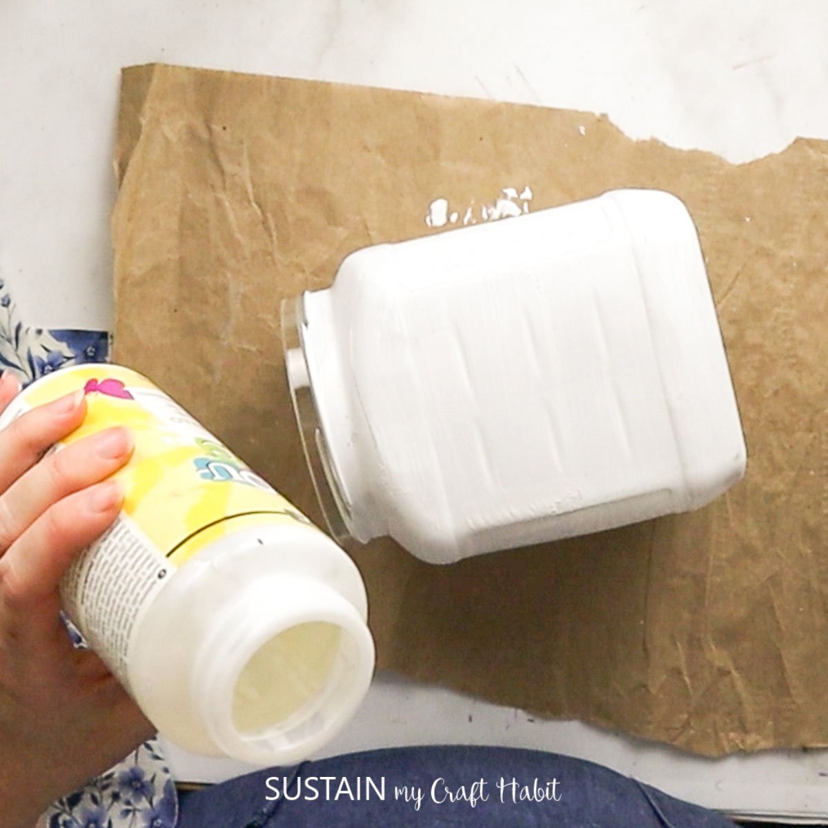 Apply decoupage glue onto a painted canister.