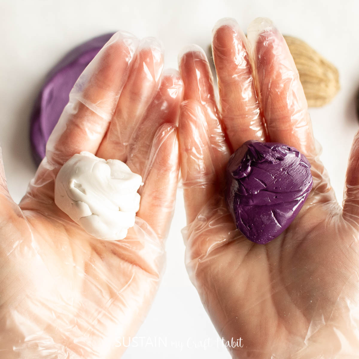 Hands holding a piece of white and purple silicone putty.