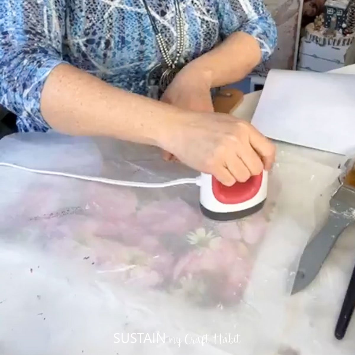 Using a mini iron to press the napkin onto the cutting board.