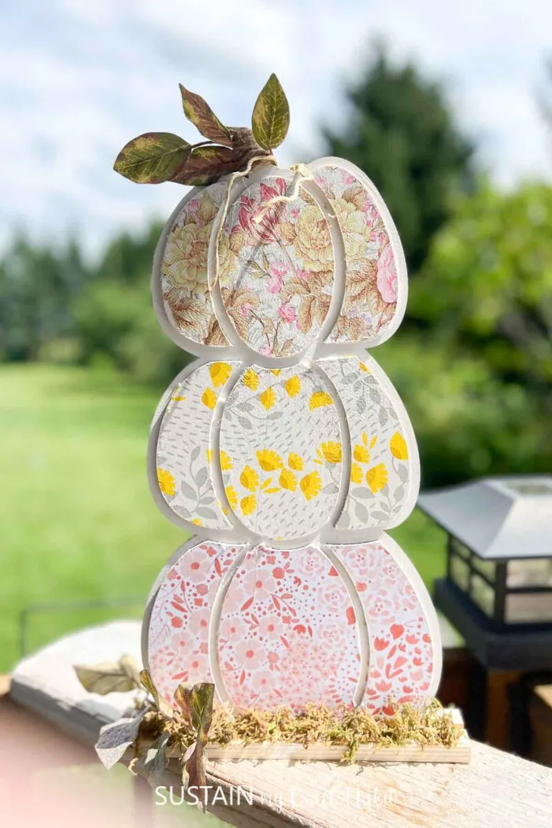 Wood pumpkin cutout crafted with decoupage and colorful paper napkins.