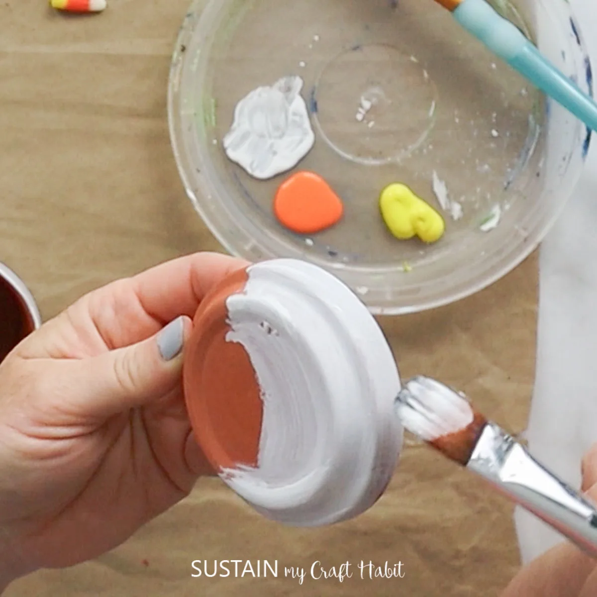 Painting a clay saucer white.
