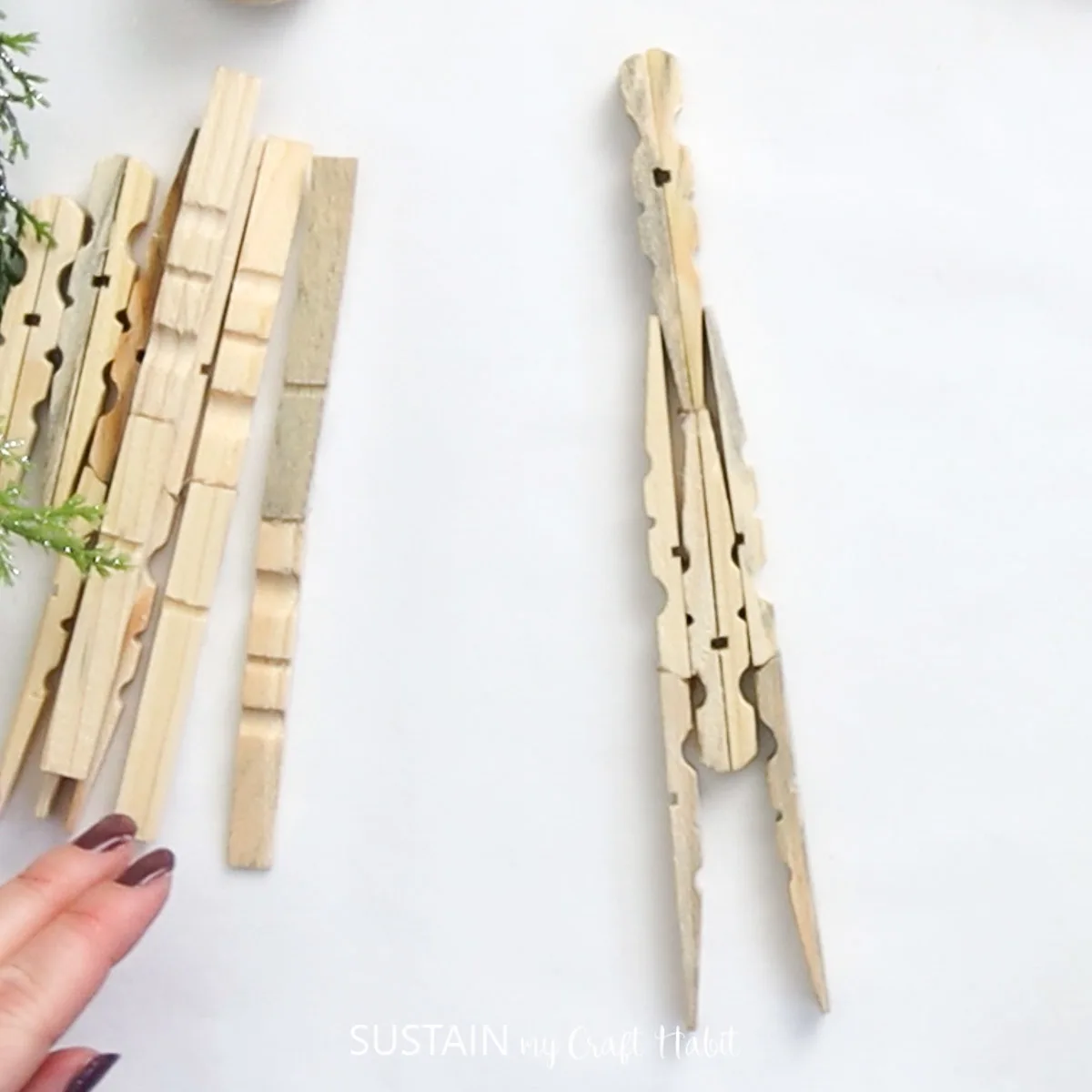 Gluing clothespins together to form an angel body.