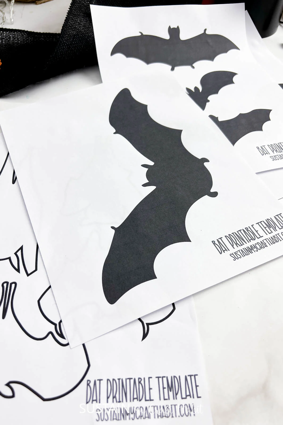 Various printable bat stencils and templates on a white table.