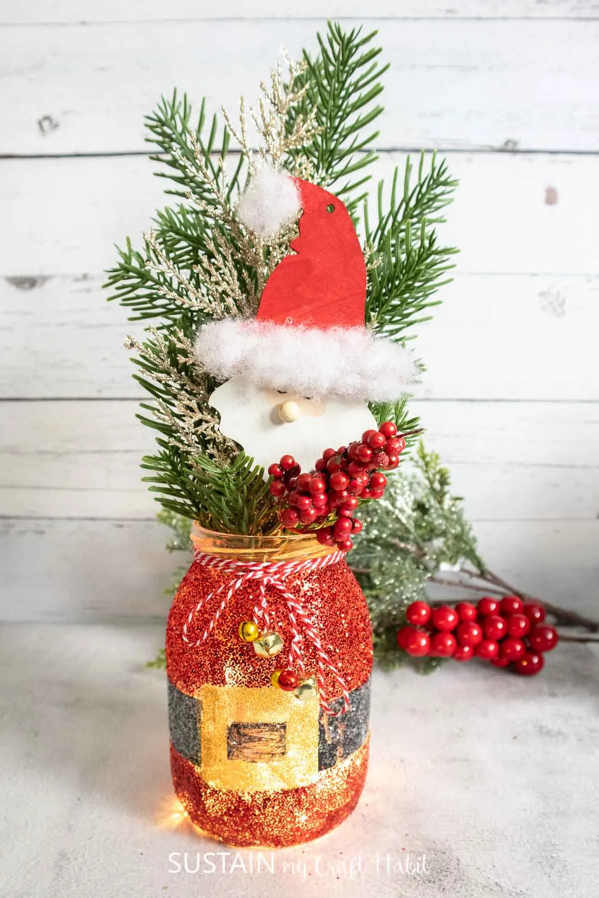 Glittering Santa Claus mason jar craft decorated with embellishments.