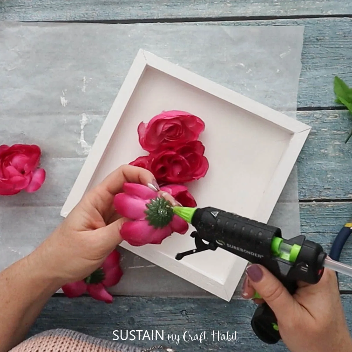 Adding hot glue to a faux flower.