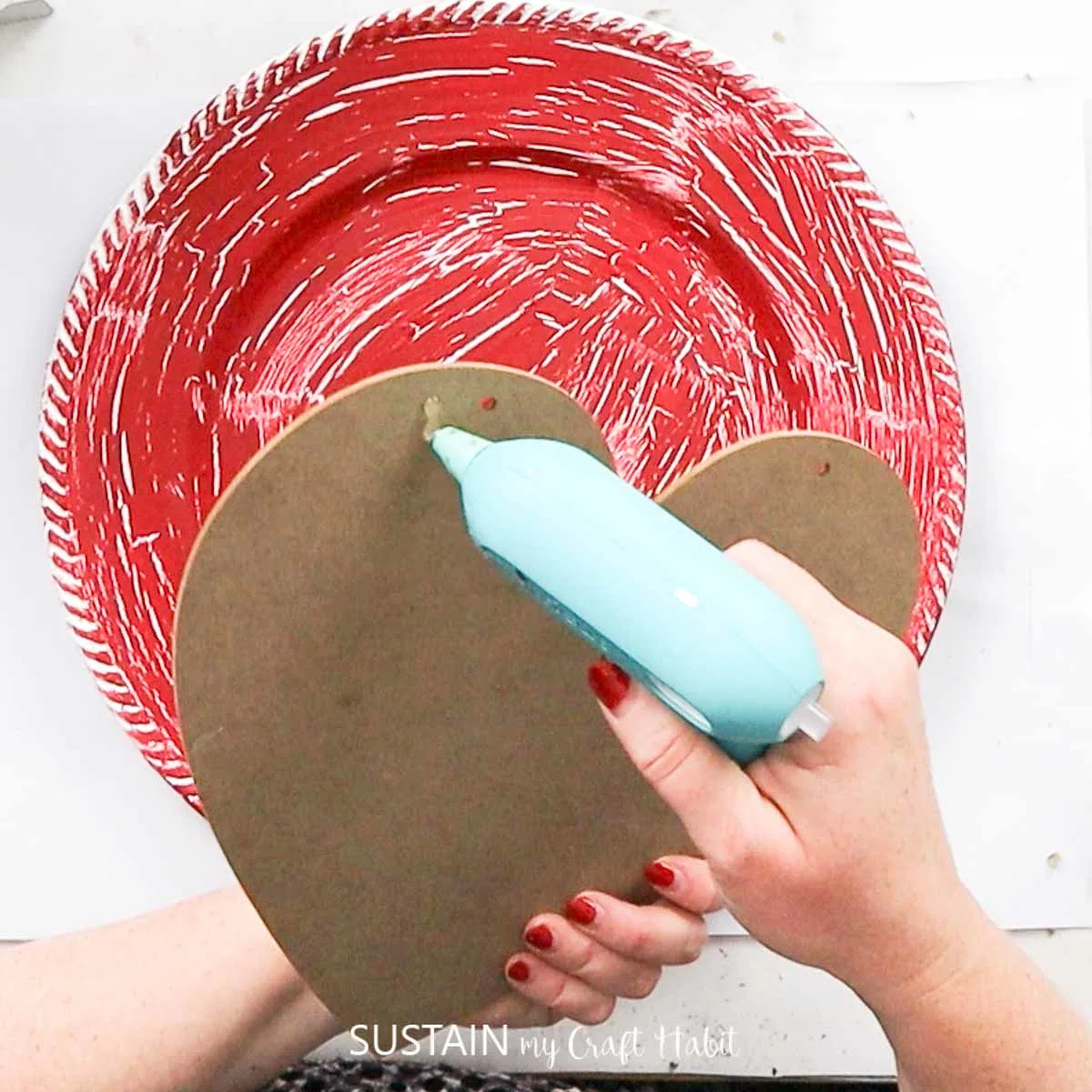 Adding hot glue to a heart sign.
