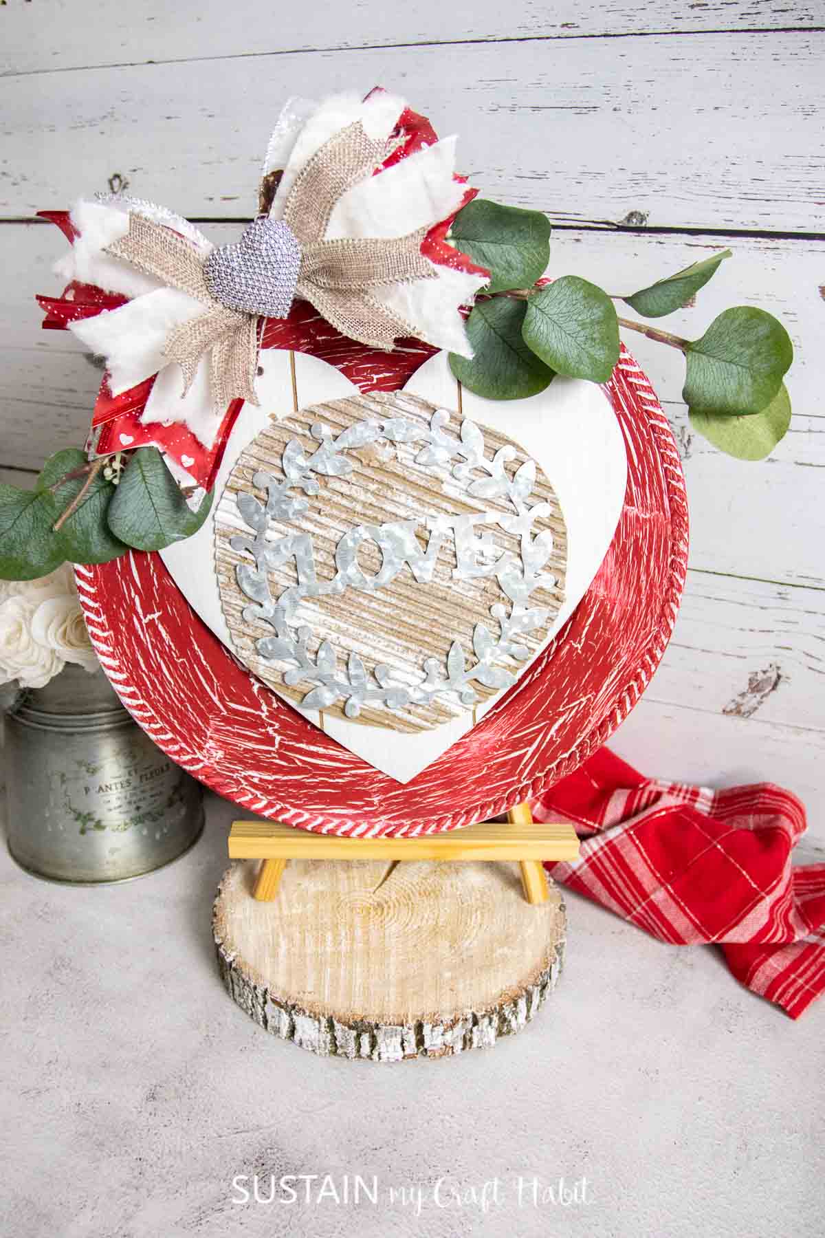 Valentine's day charger craft displayed on a wood stand. 