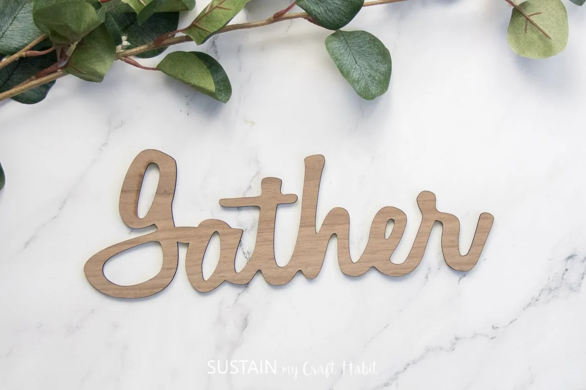 Laser cut wood sign that says "gather."