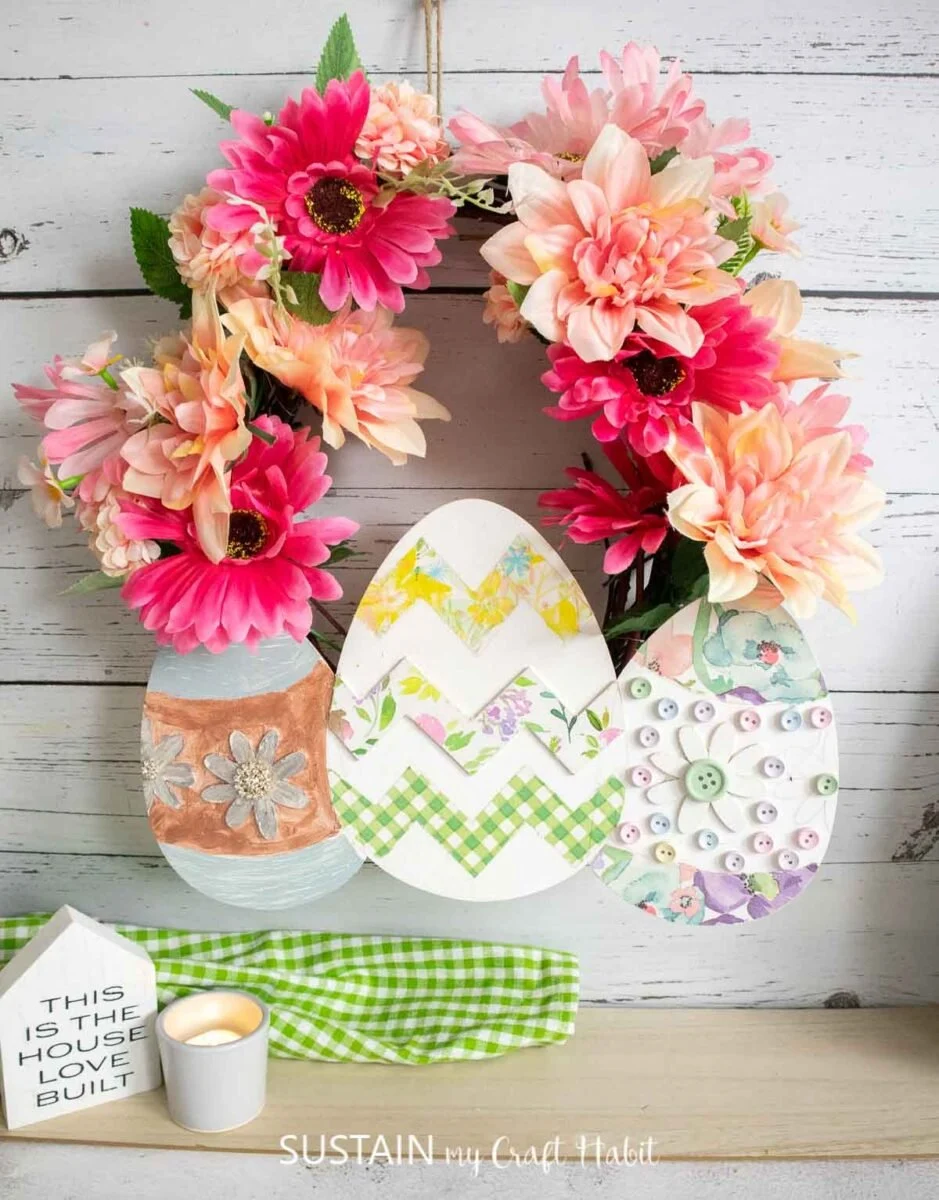 Easter wreath made from faux flowers and decoupaged wood Easter eggs.