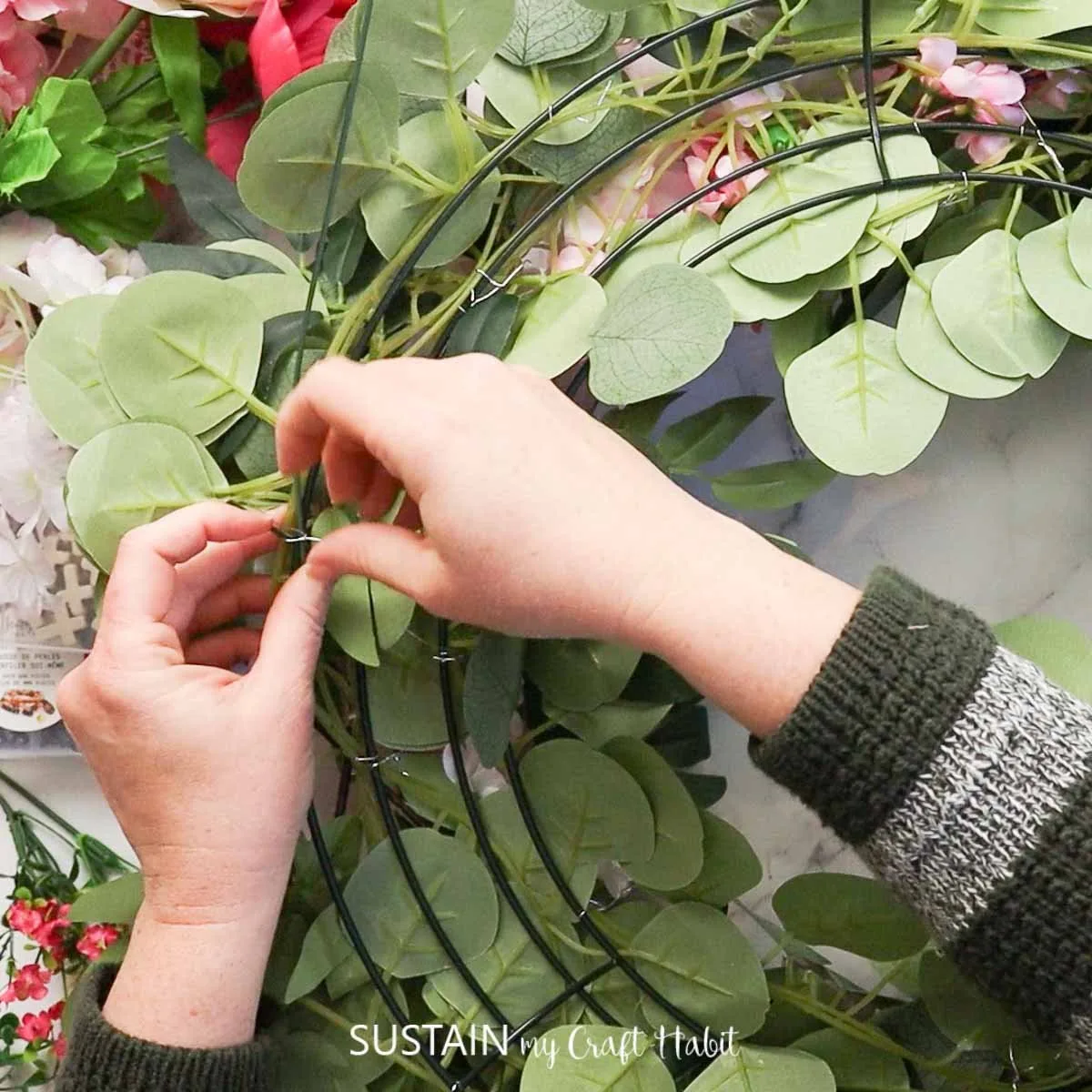 Tying flowers onto the wreath form.