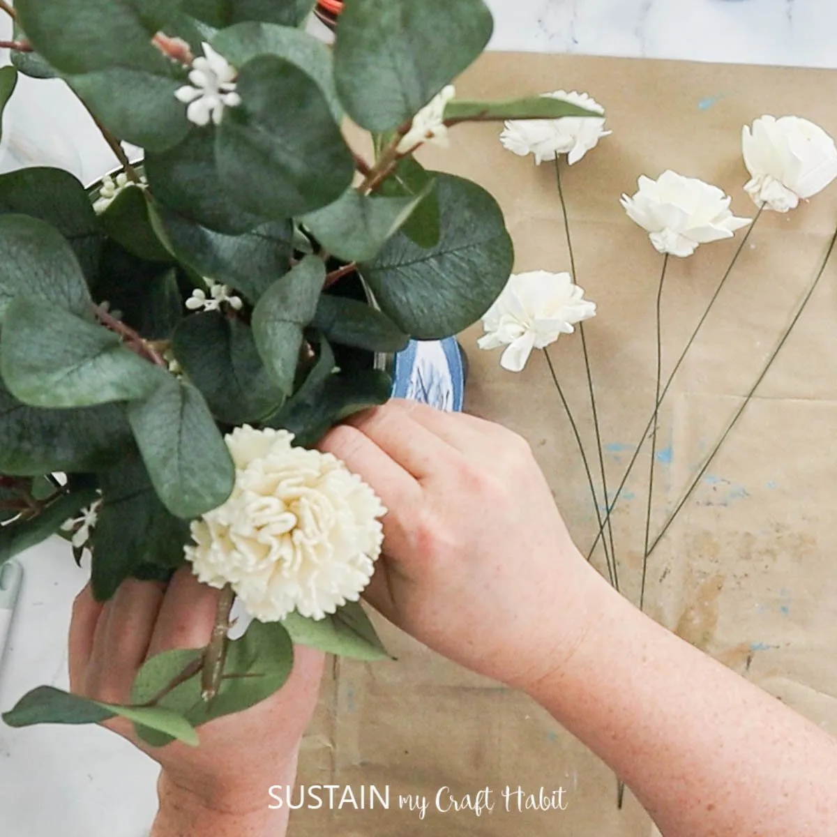 Adding flowers to the tin can.