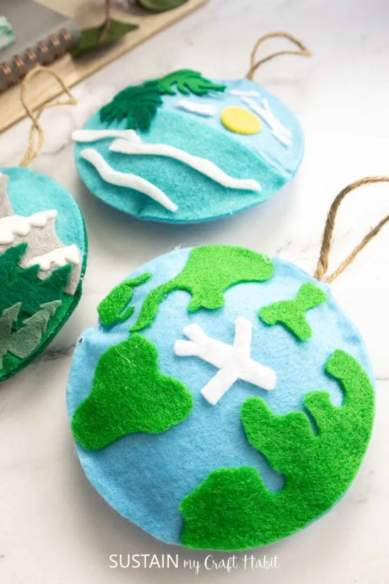 Felt travel ornament showing an airplane flying across a globe.