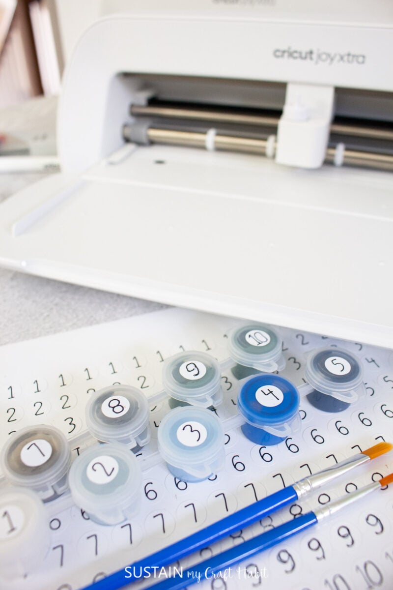 Paint containers with numbered stickers made with Cricut Joy Xtra.