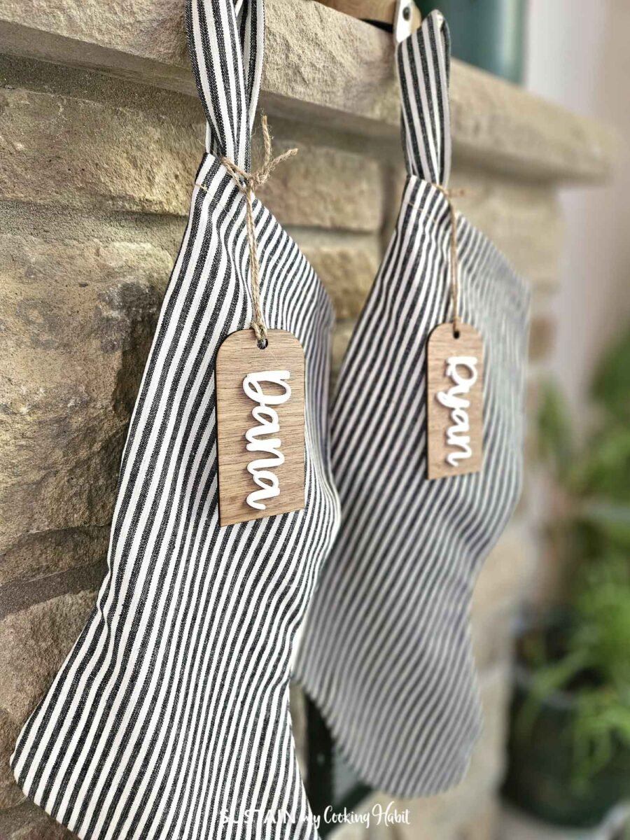 Christmas stockings on a mantel with personalized stocking tags.