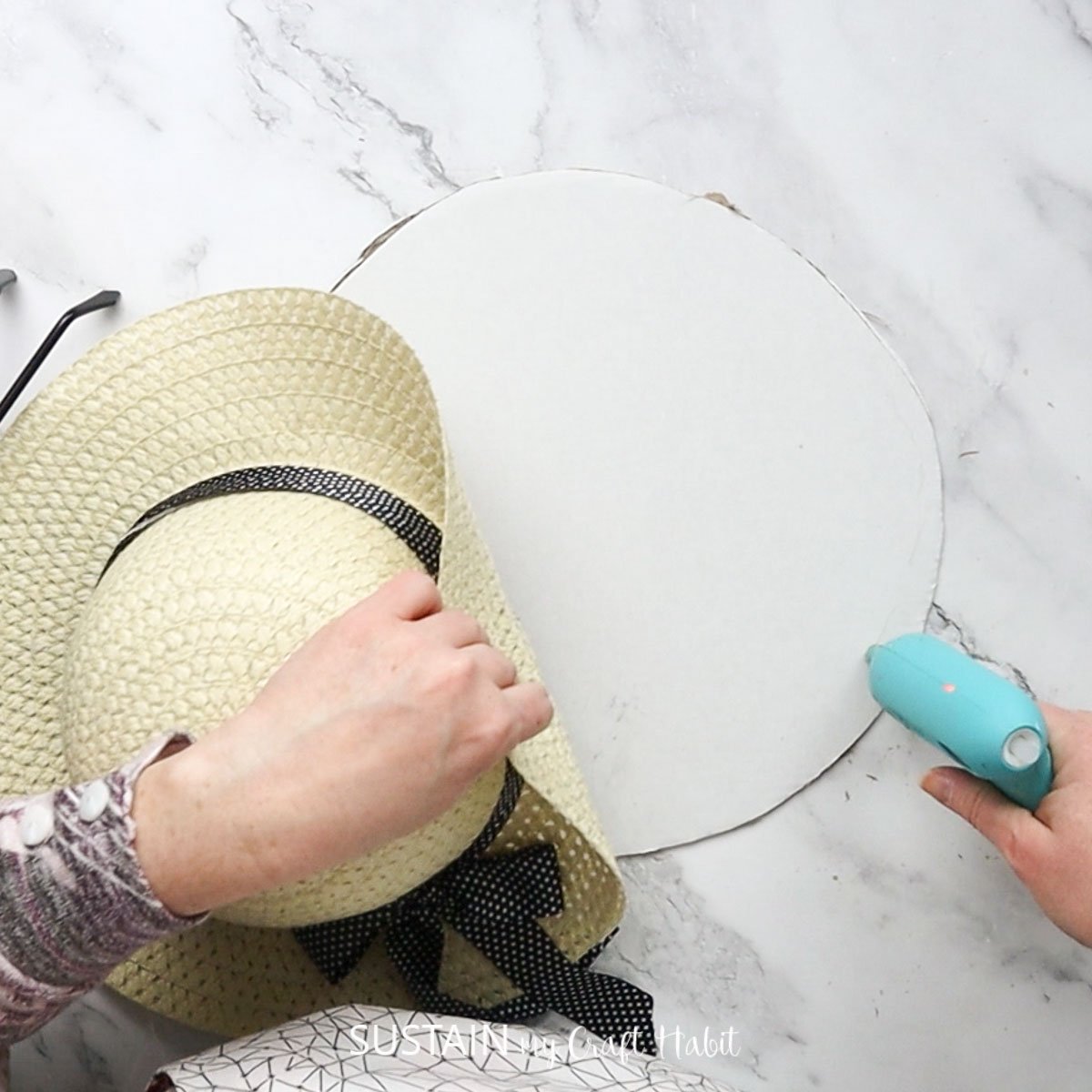 Adding hot glue to a piece of cardboard. 