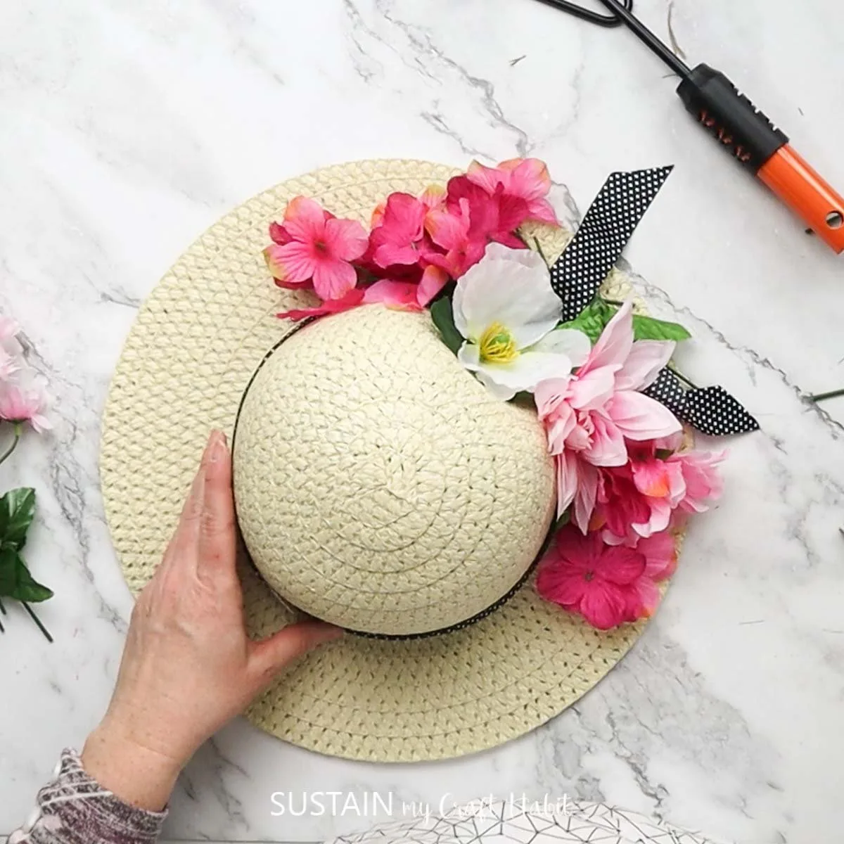 Straw hat decorated with faux flowers.