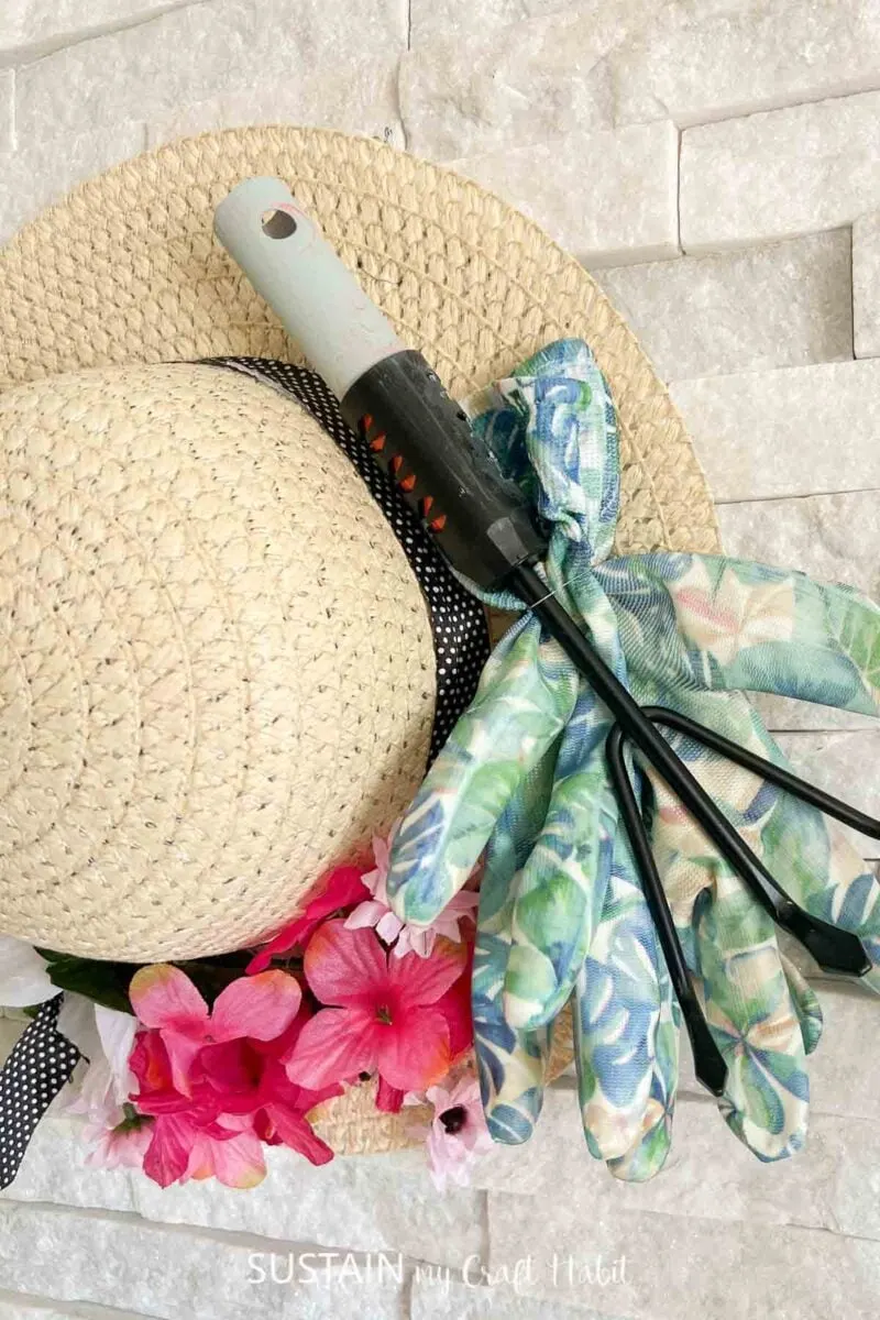 Close up of gardening tools on straw hat door hanger.