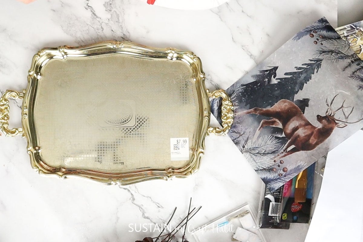 Materials needed to upcycle a silver tray including a tray and decoupage paper.