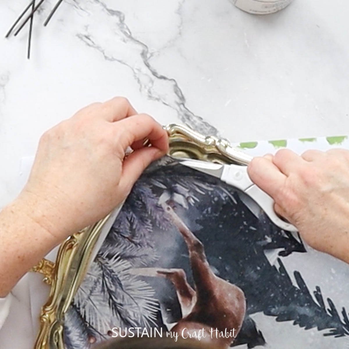 Cutting excess decoupage paper. 