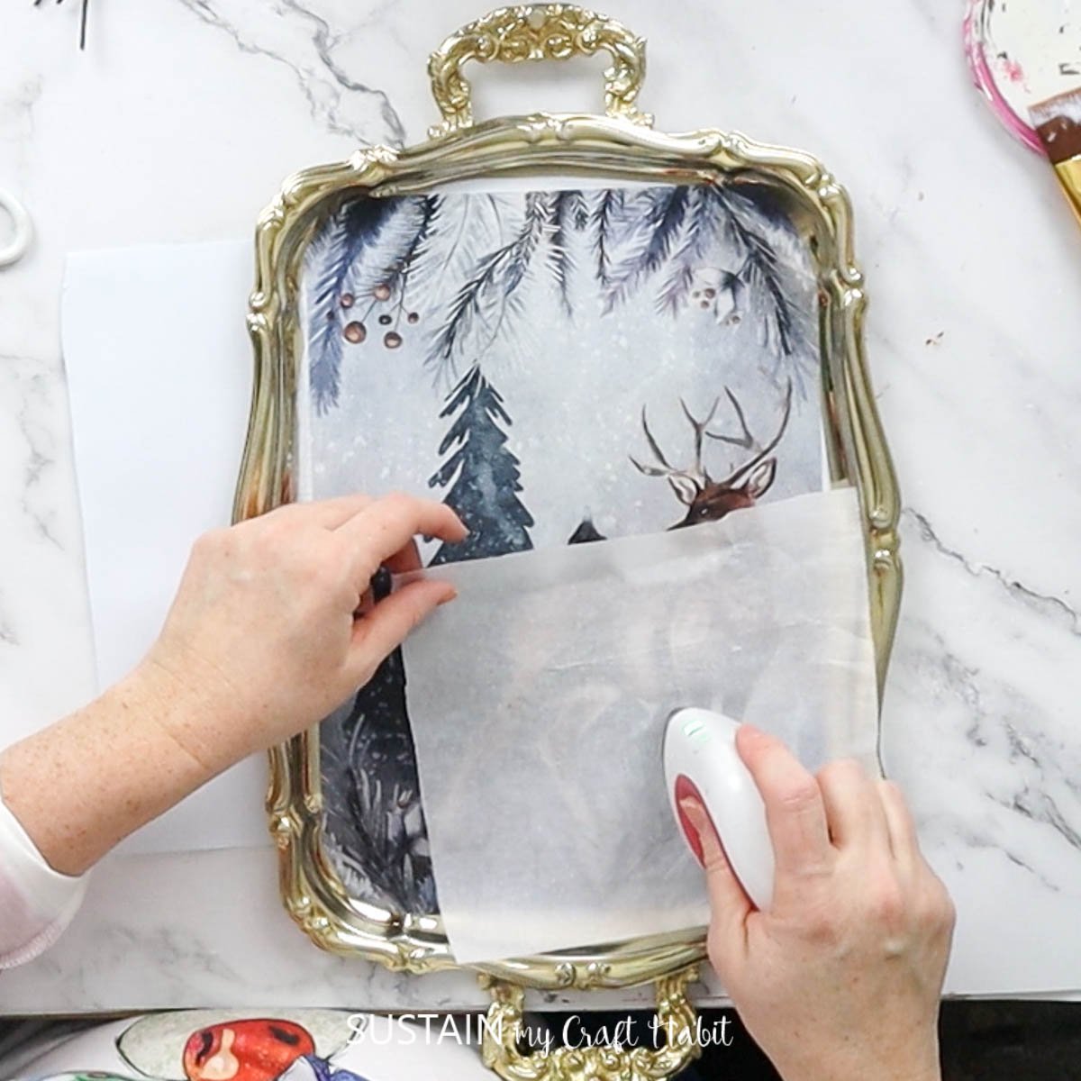 Rubbing a mini heating iron over the decoupage paper. 