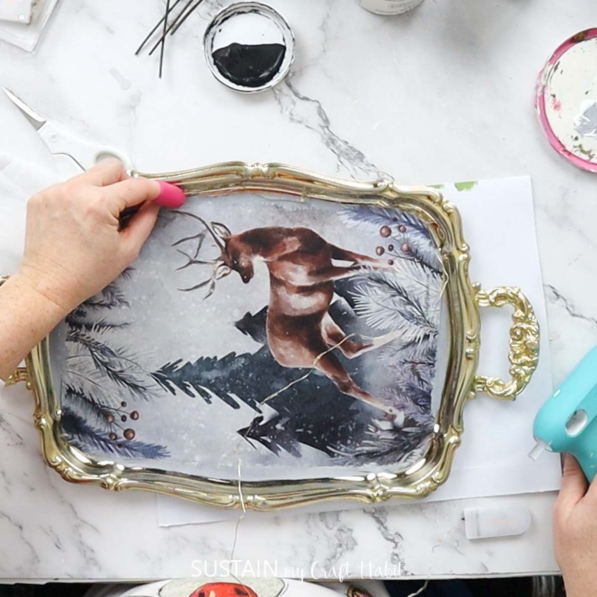 Gluing twinkle lights to the edge of the silver tray. 