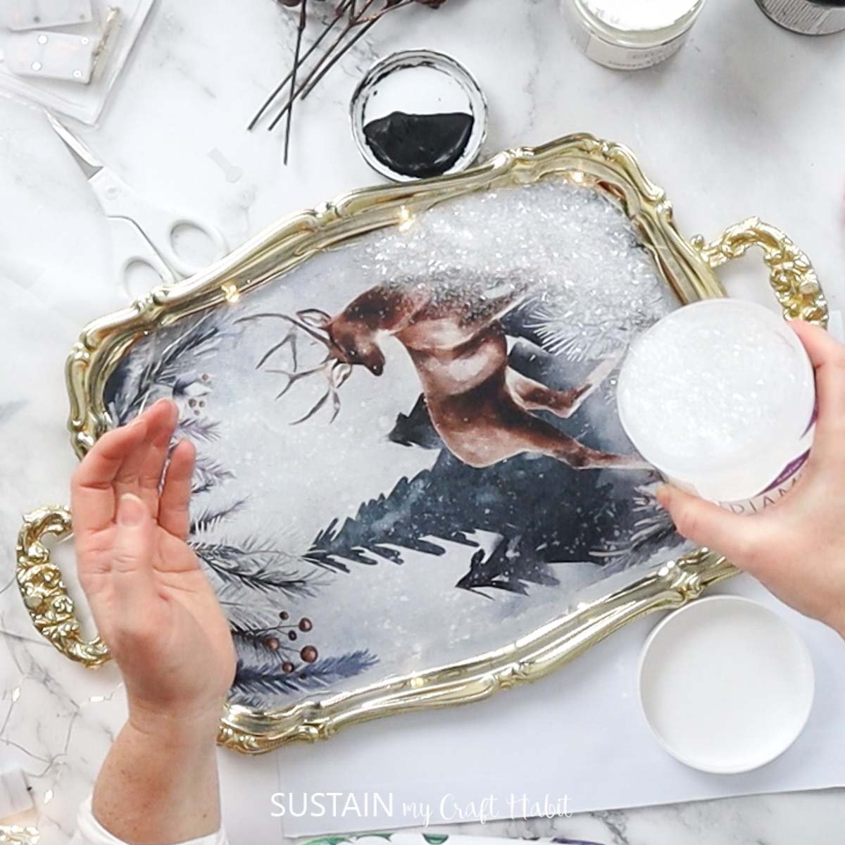 Sprinkling diamond dust over the decoupage. 