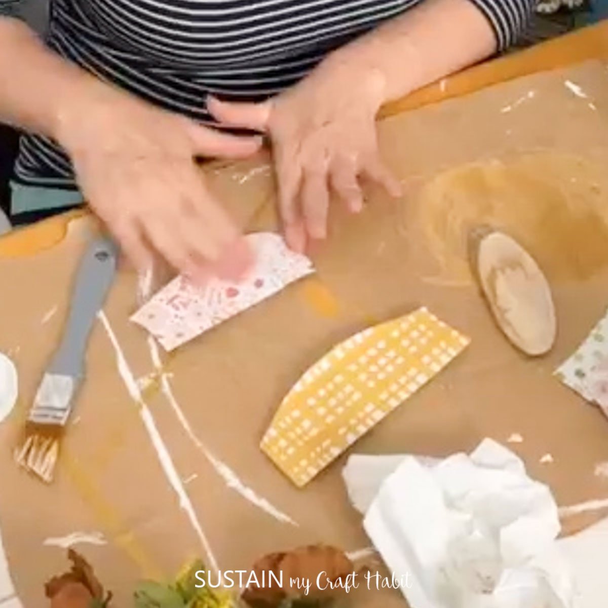 Gluing paper onto a wood slice.