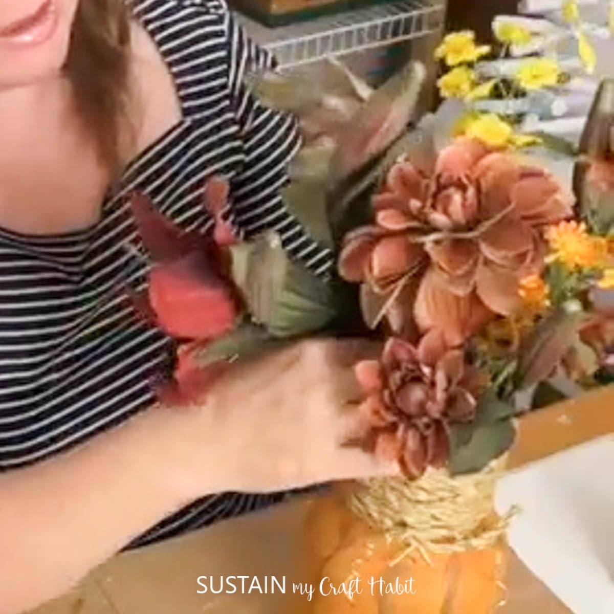 Filling mason jar with flowers.