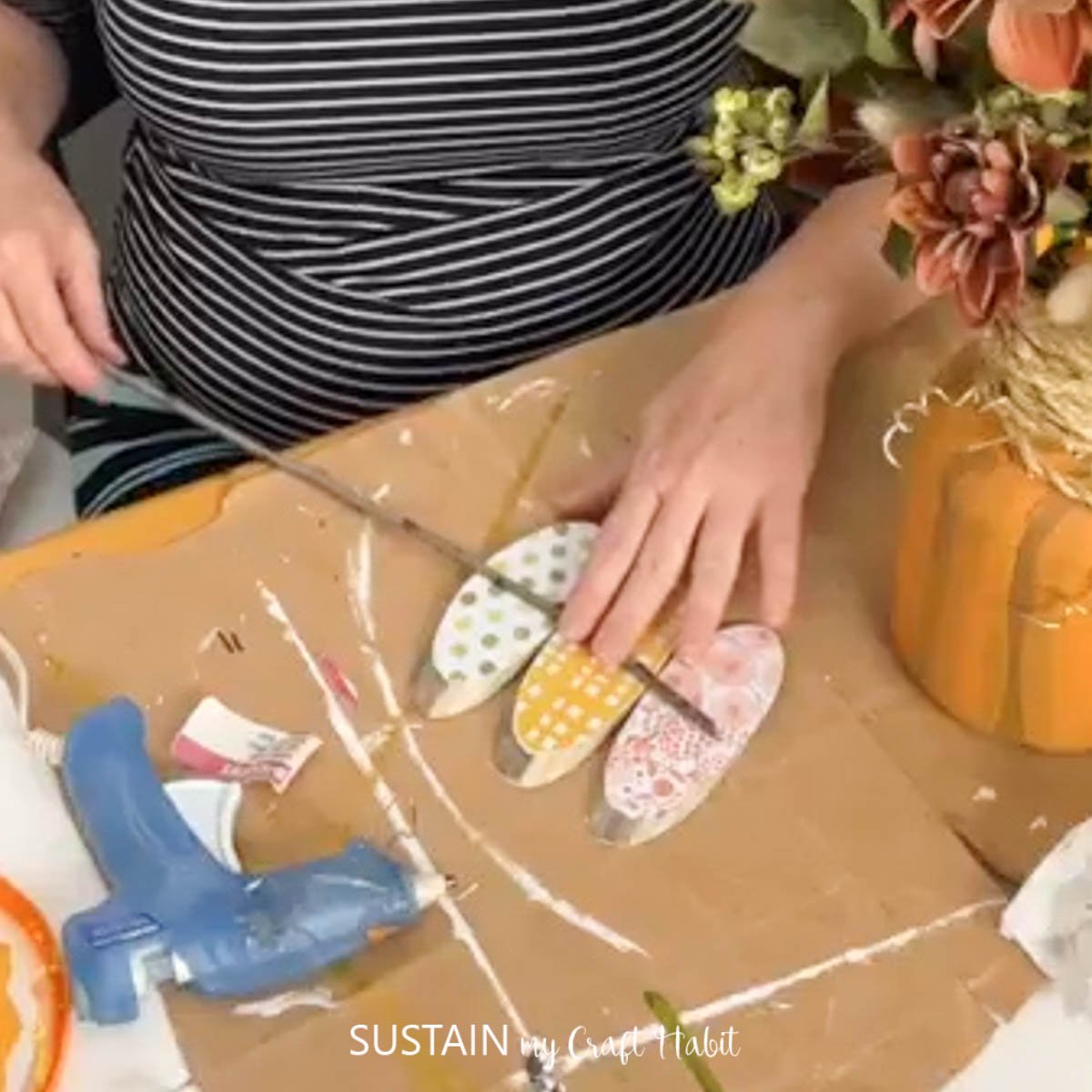 Gluing wood slices onto a twig.