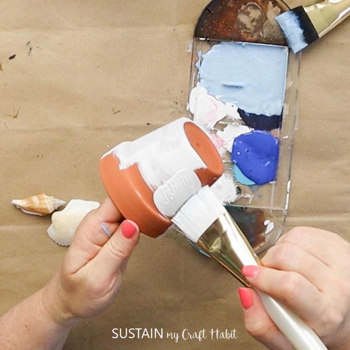 Painting a clay pot white.