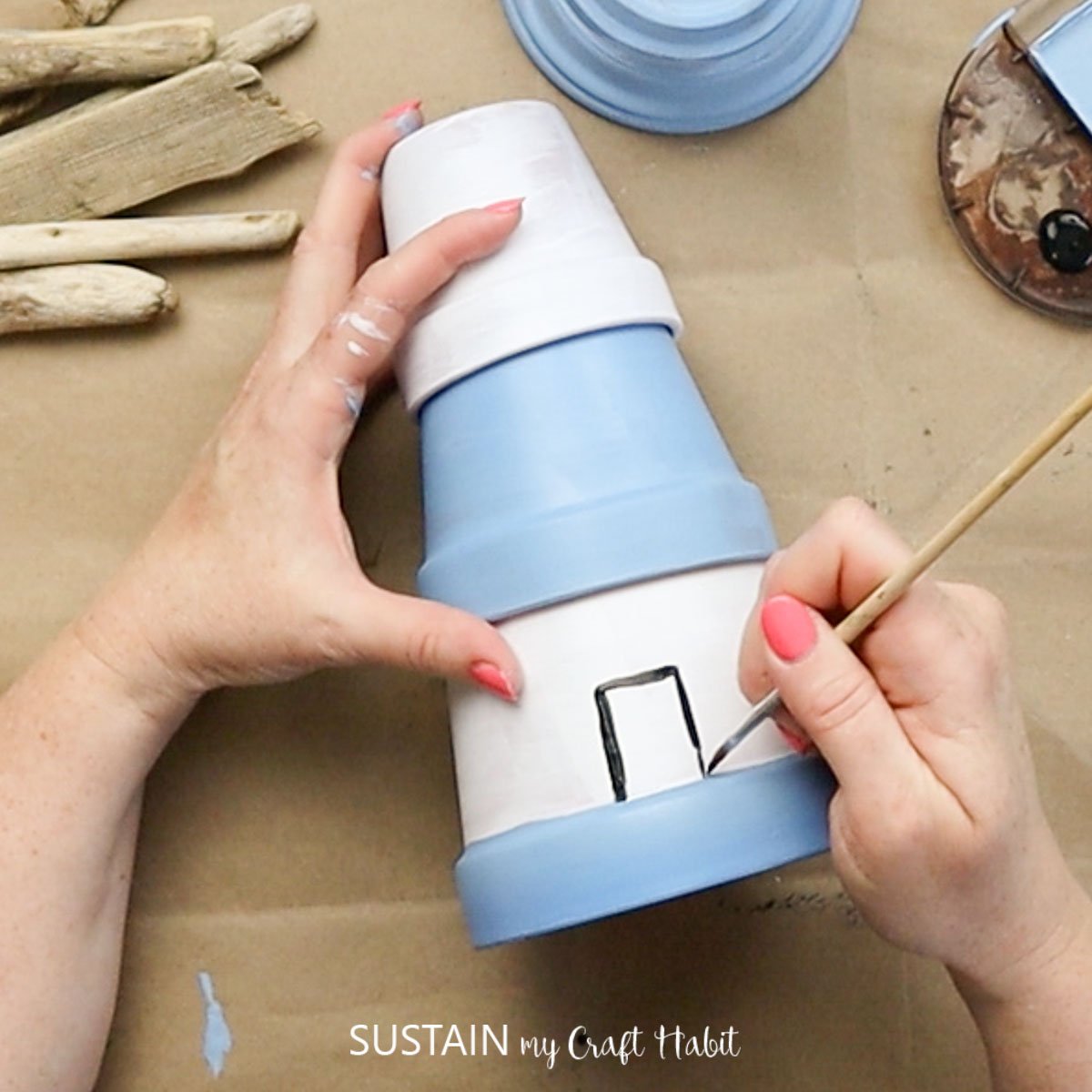 Painting a door onto a clay pot.